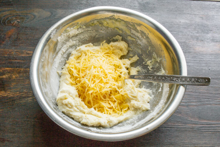 Incorporamos el queso curado Queso curado rallado cayendo sobre la masa de las quenelles