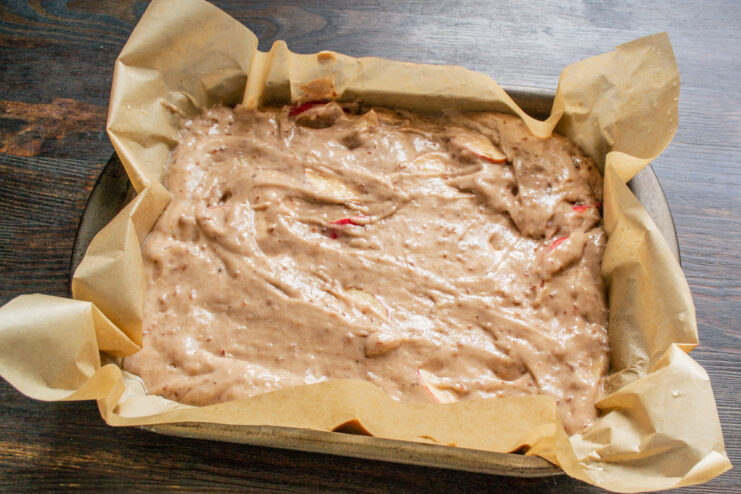 Masa de tarta de manzana distribuida en un molde para horno