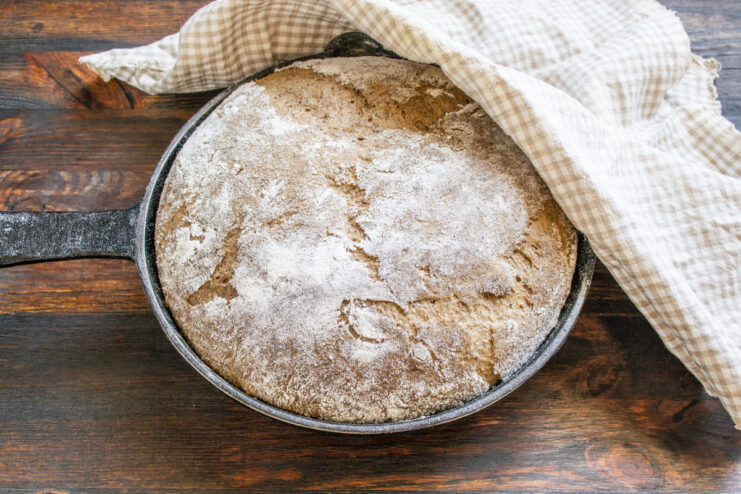 Fermentación final del pan Masa de pan dentro del molde cubierta con un paño de cocina