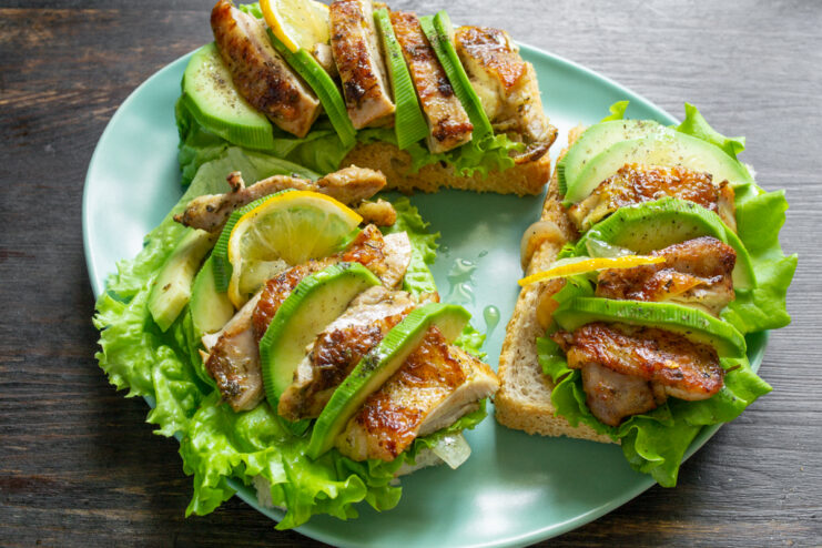 Tres tostas caseras de pollo y aguacate recién preparadas listas para servir.