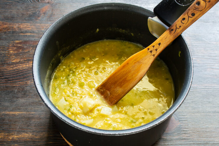 Cocción de la crema a fuego lento Crema de lentejas y quinoa cociéndose en un cazo tapado