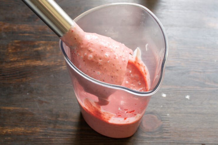 Elaboración de la crema de fresa Batido de la crema de fresa con una batidora de mano