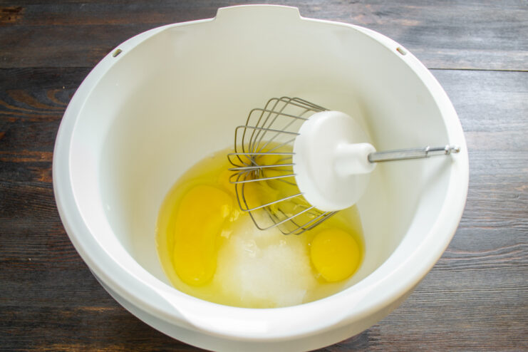 Inicio de la masa de bizcocho Huevos y azúcar en el vaso de la amasadora