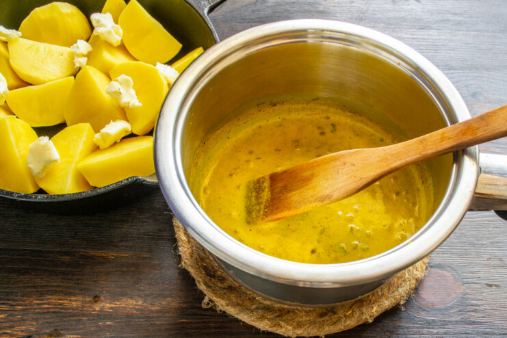 Salsa de leche dorada con especias hirviendo suavemente en un cazo
