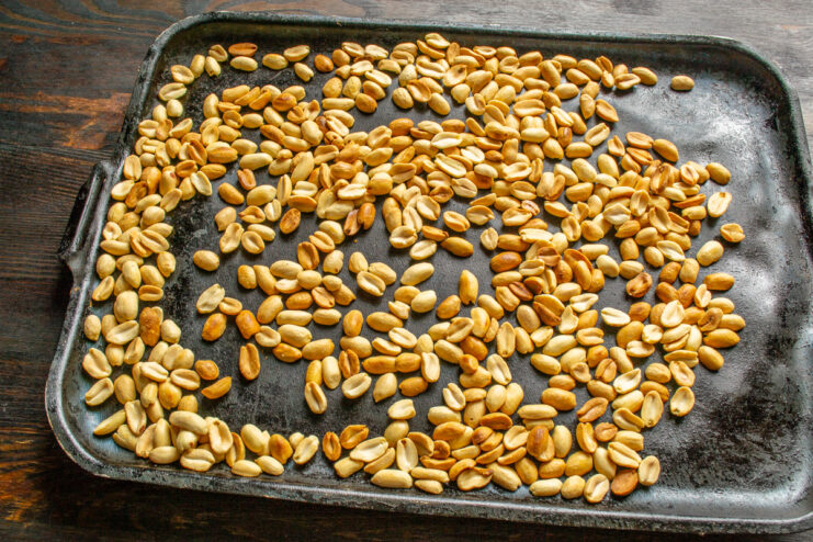 Cacahuetes tostados Cacahuetes con un tono dorado claro recién tostados en la bandeja de horno.